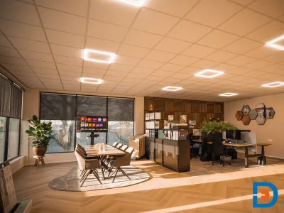 Vergaderopstelling en vier werkplekken in een functionele kantoorinrichting.