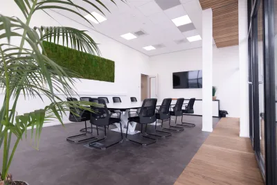 Lichte en moderne vergaderruimte met een imposante witte tafel voorzien van een stevig, robuust onderstel.