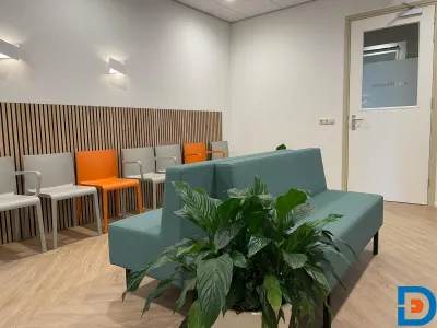 Wachtkamer voor patiënten bij de huisartsenpraktijk, ingericht voor comfort en rust.