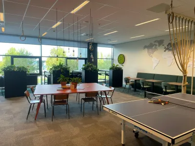 Lerarenkamer met vergadertafel en zitplekken in een functionele kantoorinrichting.