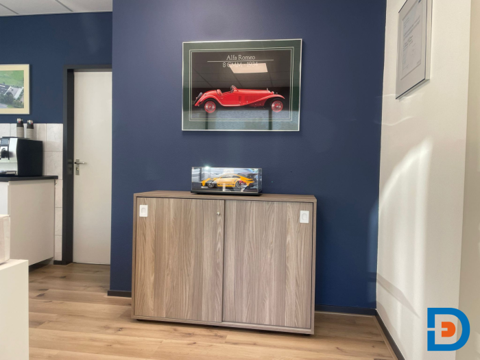 Kast in dezelfde kleur als de balie, met een moderne uitstraling en een functionele indeling, geplaatst bij Goossen Autoschade.