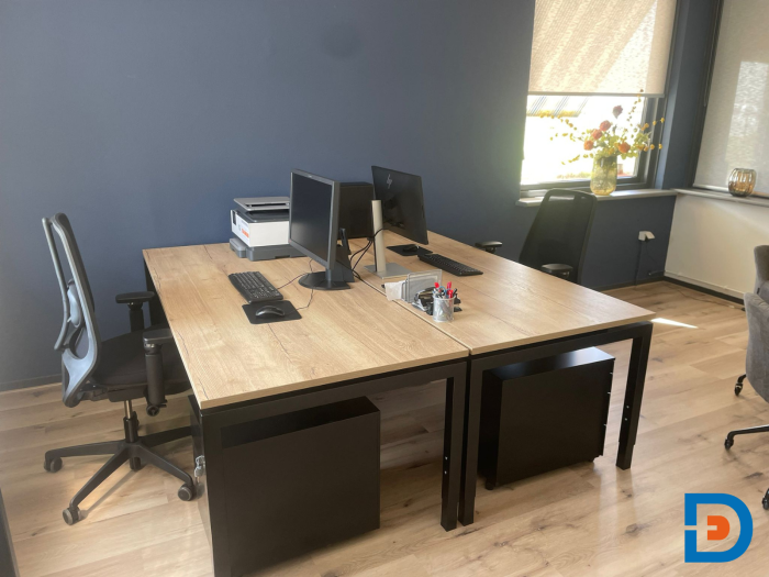 Ergonomische werkplekken met bureaustoelen die ondersteuning bieden voor een gezonde werkhouding. De ruimte is uitgerust met opbergmeubels, waaronder ladeblokken, voor een opgeruimde en efficiënte werkomgeving.