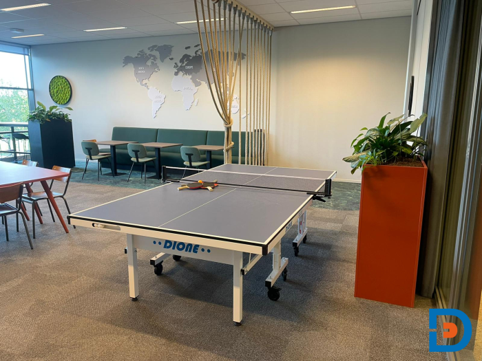 Lerarenkamer met vergadertafel en zitplekken in een functionele kantoorinrichting.