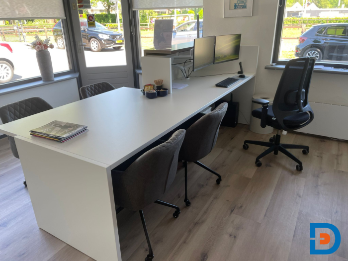 Moderne werkplek bij de balie van Goossen Autoschade, met een strak bureau en comfortabele stoelen voor personeel en klantenontvangst.