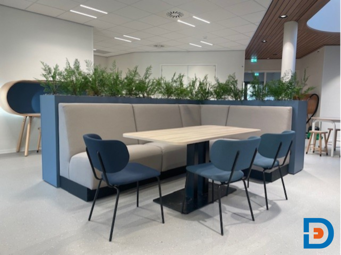 Maatwerk treinbank met kolomtafel en comfortabele gestoffeerde stoel.