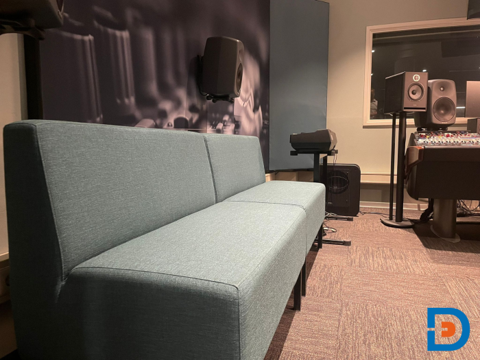 Studio bij ArtEZ Conservatorium met geluidsdichte wanden, mengpaneel, speakers en moderne bank in opnameruimte
