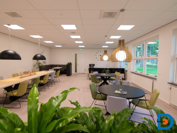 Sfeervolle personeelskamer met voldoende zitplekken en een aantrekkelijke variatie aan ronde tafels.