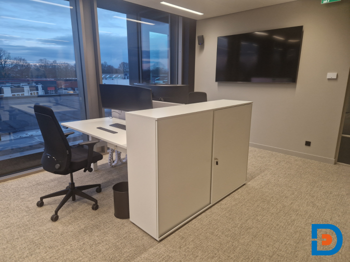 Witte werkplekken met frisse uitstraling, gecombineerd met een houten schuifdeurkast.