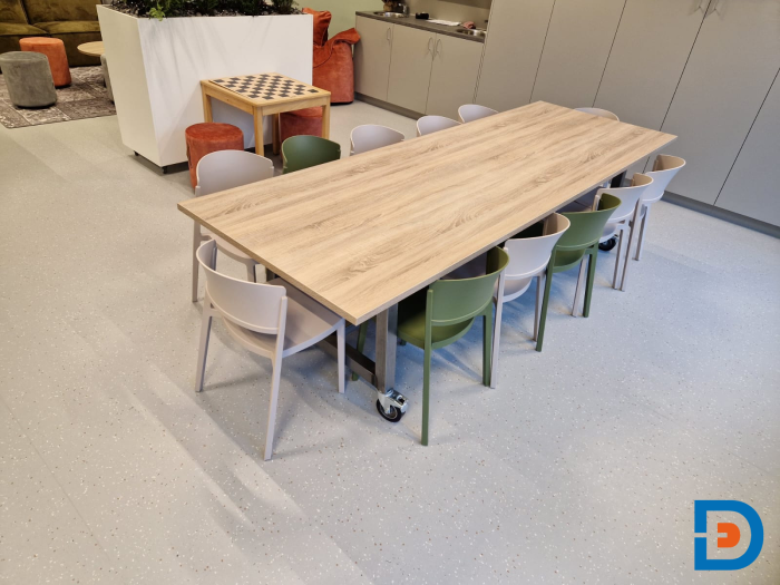 Speeltafel met kleurrijke stoelen in een lichte ruimte, ideaal voor eet- en speelsessies voor kinderen.