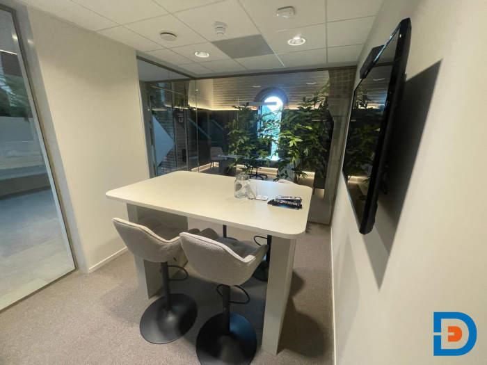 Kleine vergaderruimte voorzien van een hoge maatwerktafel, ideaal voor korte overleggen en of vergaderingen / gesprekken