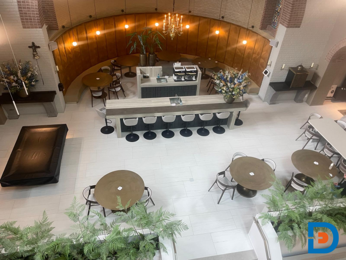 Hergebruikte kerkbanken gecombineerd met moderne tafels en stoelen voor een unieke mix van klassiek en eigentijds.