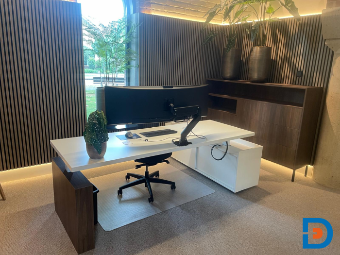 Directiewerkplek met elektrische zit/sta-functie en maatwerk wangenpoot voor optimale ergonomie en stijl.