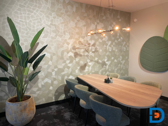 Sfeervolle vergaderruimte met houtentafel en groen accenten, mooi in combinatie met arte behang