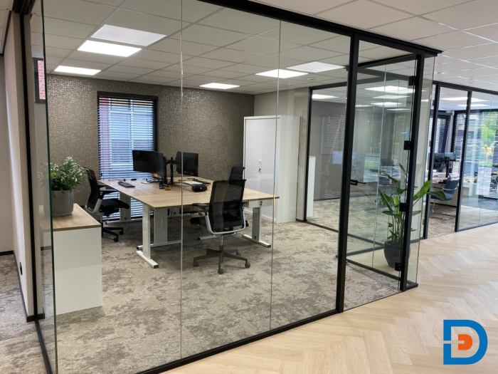 Lichte kantoorruimte met glazen wanden, pvc- en tapijtvloeren en aantrekkelijke werkplekken