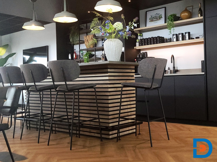 Functionele maatwerkkeuken met bar en een moderne lattenwand als sfeervol detail.