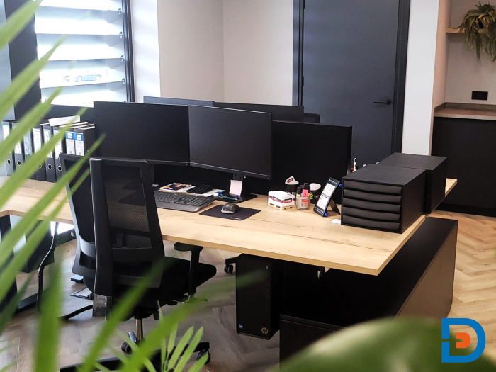 Elektrische zit/sta-werkplek met hoekopstelling en geïntegreerde opbergruimte.