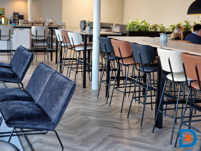 Personeelskamer met visgraat PVC-vloer, stijlvolle barkrukken en een rustig kleurpalet.