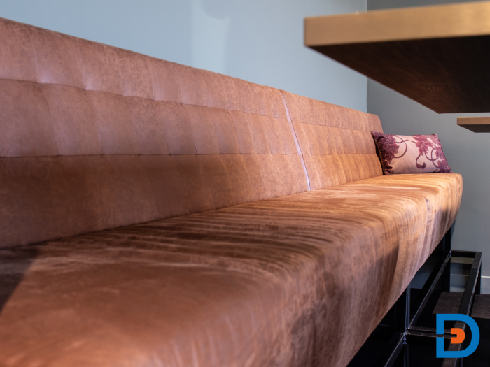 Gestoffeerde treinbank met gecapitonneerde rugleuning voor een tijdloze, klassieke uitstraling.