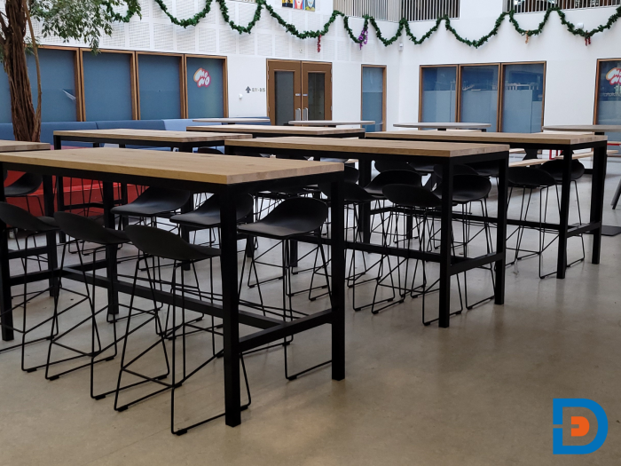 Robuuste statafels met eikenhouten blad, gecombineerd met stijlvolle barkrukken.