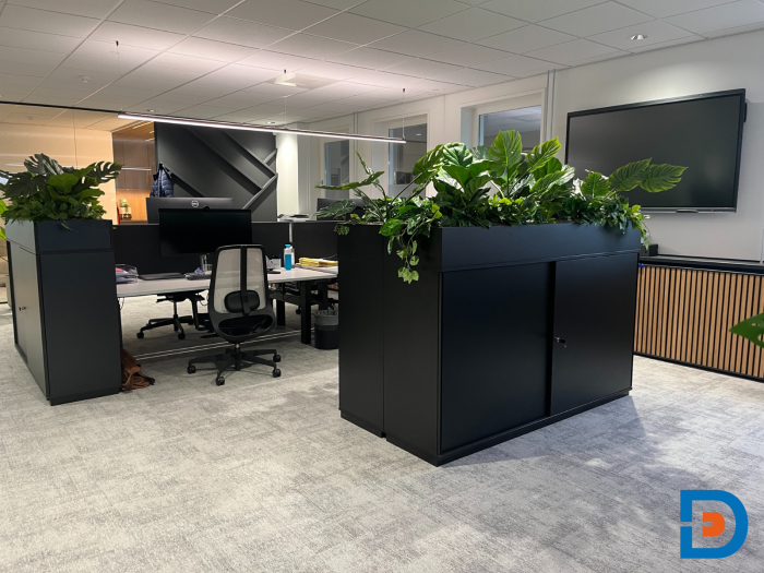 Moderne kantoorinrichting met open werkplekken en plantenbakken