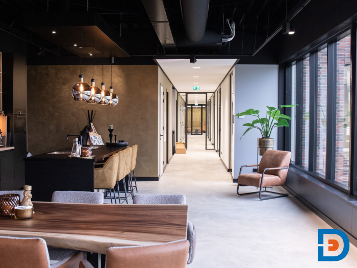 Sfeervol doorkijkje vanuit de kantine naar de kantoren, waar licht en design harmonieus samenkomen.